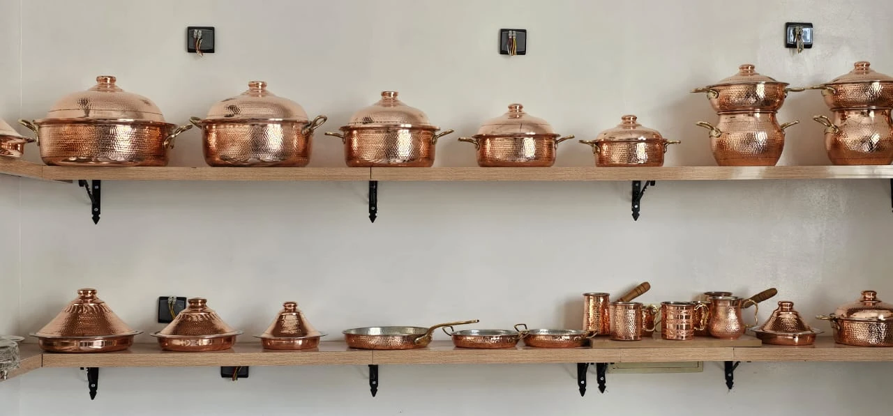 Ensemble de pièces de cuisson en cuivre présentées sur des étagères