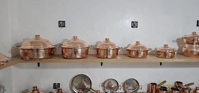 Plusieurs marmites avec couvercles sur une étagère