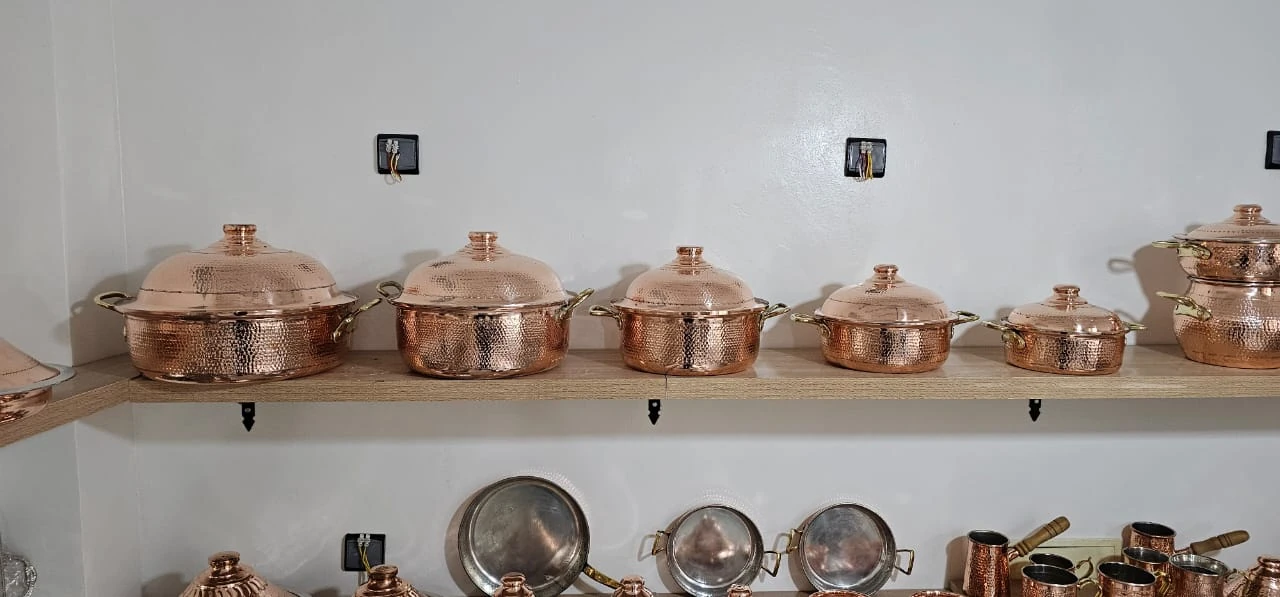 Plusieurs marmites avec couvercles sur une étagère